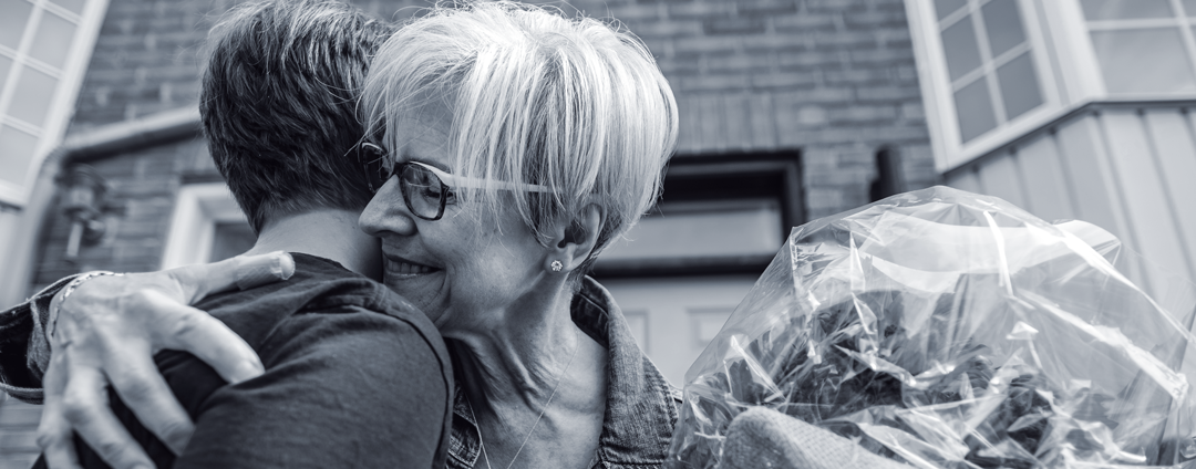 A teenage boy and grandma hugging each other