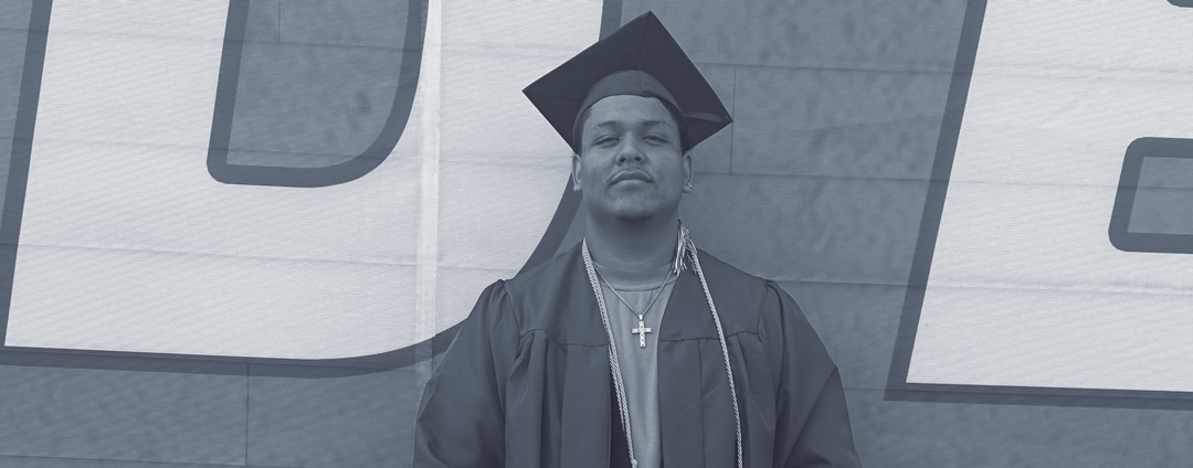 Robin in his cap and gown, holding his high school diploma