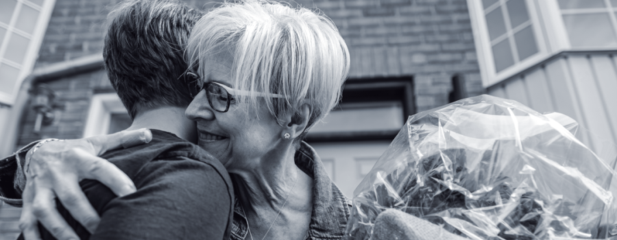 A teenage boy and grandma hugging each other