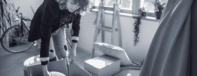 young adult packing a moving box